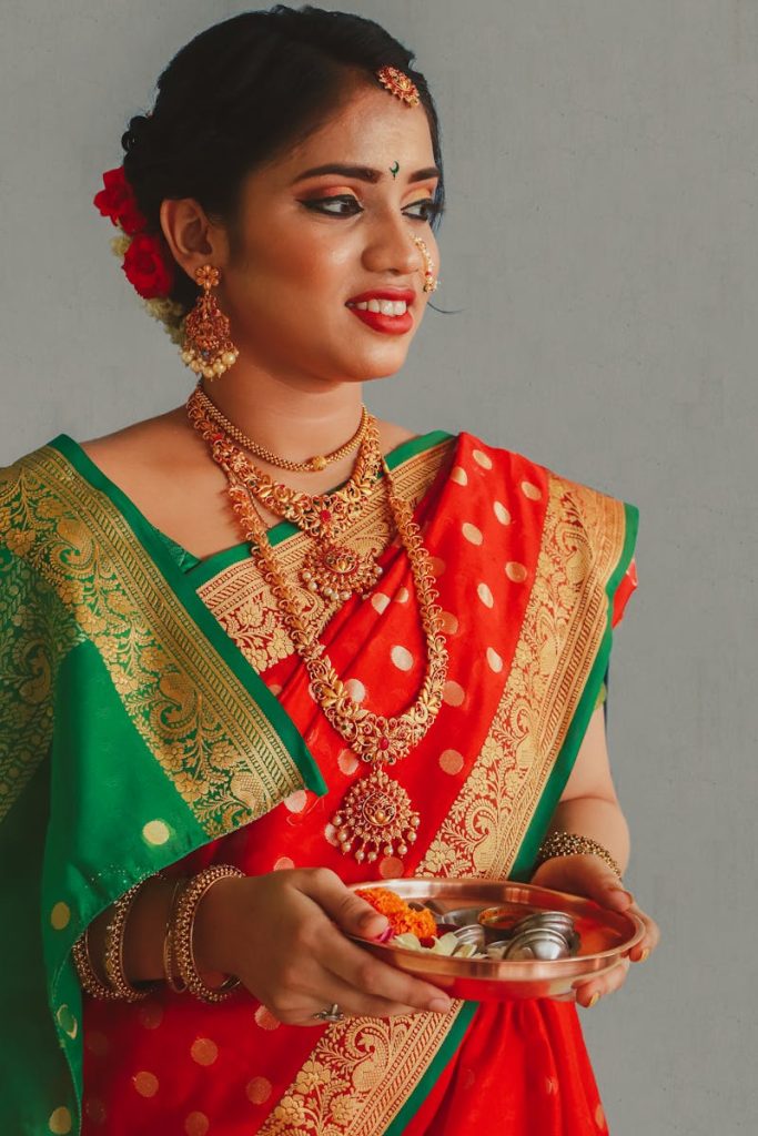 Portrait of a woman in traditional Maharashtrian attire holding a Pooja thali.